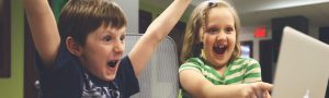 Children celebrating in front of a laptop