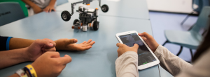 Students programming robot with tablet