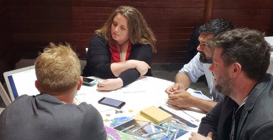 Group of people sitting at a round table including Shawn Young working on creating a Classcraft quest