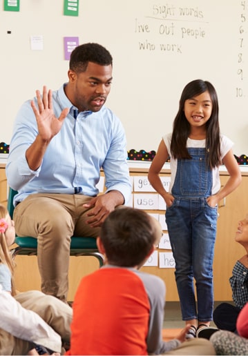 Une élève devant son groupe avec son enseignant