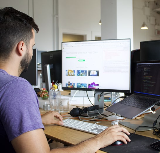 Un homme devant son ordinateur en train de travailler sur le code de Classcraft