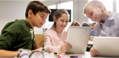 3 élèves travaillent en équipe sur une tablette