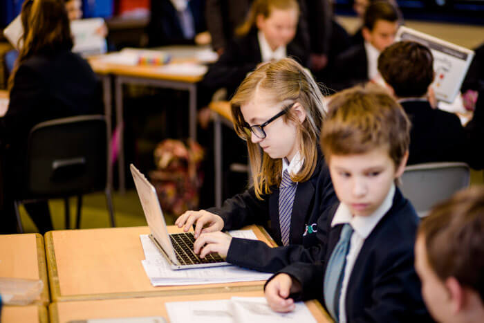 students in class working seated at their desks