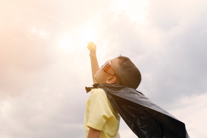 superhero kid pointing at the sky
